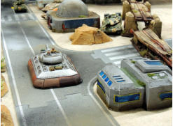 Slammers command tank rumbles down the road into town facing off the NUA but a Molot emerges to fire - and damages but fails to stop him