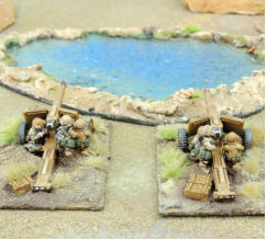 Two Tyche anti-tank towed weapons deployed and in action at an oasis